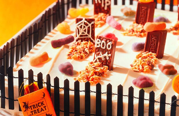 Un bizcocho decorado como un cementerio con huesos de caramelo, lápidas y vallas.