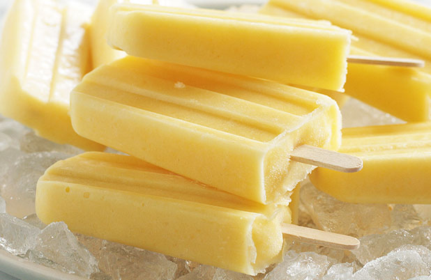 A stack of Mango Coconut Ice Pops on a pile of crushed ice.