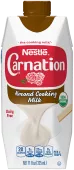 Fotografía frontal de un cartón blanco y rojo octogonal de Leche Condensada Sin Lactosa Endulzada. Tiene la marca Carnation y el logotipo de la flor, una tapa de botella de plástico marrón y una imagen de leche evaporada vertiéndose en una espátula blanca.