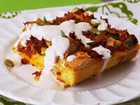 Rosca Bundt de zanahoria con glaseado y coco tostado, con el centro lleno de dulces y huevitos de Pascua rosados y azules.