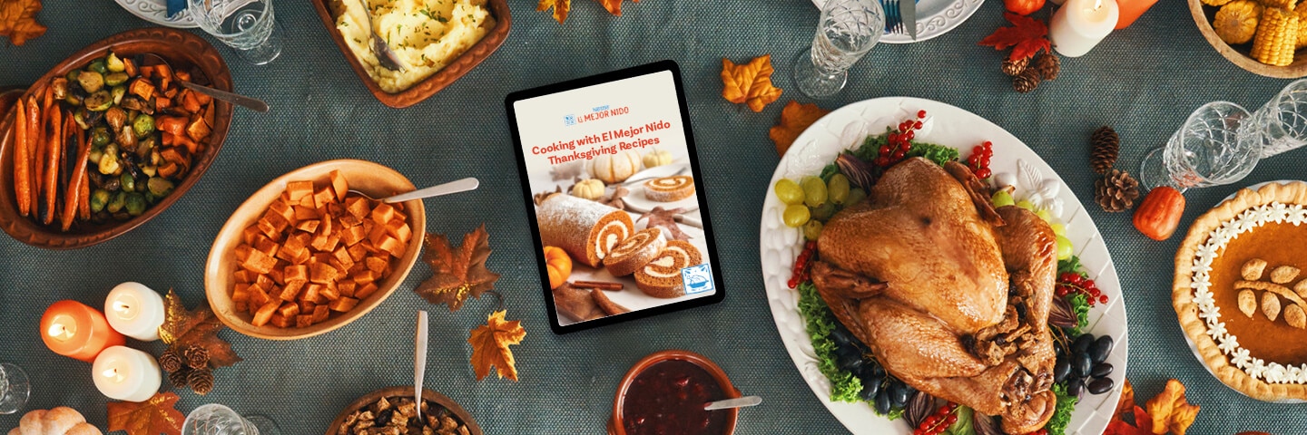 Libro de recetas de Acción de Gracias en iPad sobre una mesa de madera rodeada de pavo y acompañamientos.