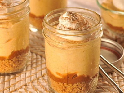 Dulce de Leche Mini Pumpkin Cream Pies on a textured wicker surface.