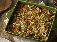 Cazuela de Ejotes con Carnation® en un Sartén Verde sobre una Superficie de Madera.